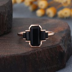 a black stone ring sitting on top of a piece of wood