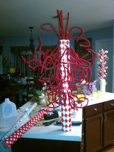 a red and white sculpture sitting on top of a counter next to a wooden cabinet