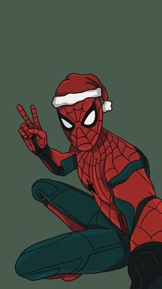 spider - man is sitting on the ground with his hands in the air and wearing a santa