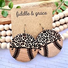 the wooden earrings are decorated with black and white leopard print fabric, which reads fiddle & grace