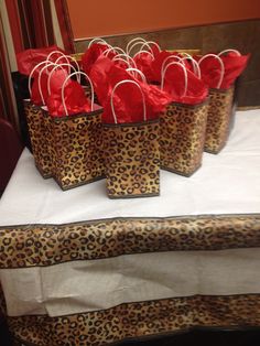 leopard print bags with red hearts on them sitting on a white tablecloth covered table