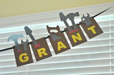 a sign that says grant hanging from a line in front of a window with the word grant on it