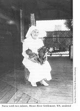 an old black and white photo of a nun holding a dog in her arms,