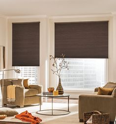 a living room filled with furniture and windows covered in roman blind shades on top of them