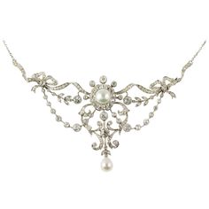 An Edwardian diamond and pearl necklace, of a natural round half pearl, measuring approximately 8.3 mm of diameter, to the centre of an old brilliant-cut diamond-set cluster all to an old brilliant-cut diamond-set scroll and bow openwork designed frame with natural pear shaped pearl drop, measuring approximately 7.7 x 6.7 mm, Gem&Pearl laboratory certificate, the diamonds estimated a total of 5 1/2 carats, on chain, circa 1910, gross weight 22.54 grams. An alluring early twentieth century piece.