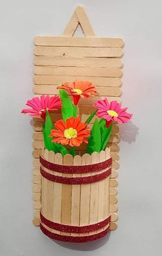 a wooden basket filled with flowers on top of a white table next to a wall