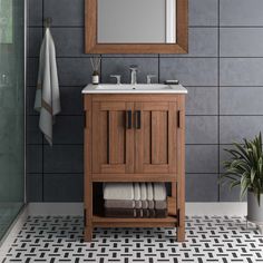 a bathroom with a sink, mirror and towel rack on the wall next to it