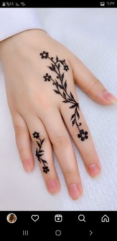 a woman's hand with black flowers on it