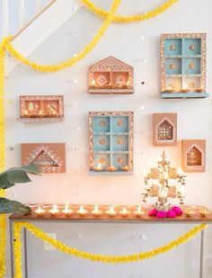 a table topped with lots of candles next to a wall covered in pictures and decorations