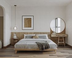 a bed sitting in a bedroom next to a wooden table and chair on top of a hard wood floor