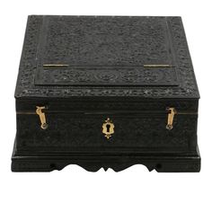 an ornate black box with gold handles on the top and bottom, sitting against a white background