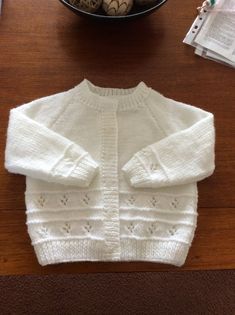 a white sweater sitting on top of a wooden table