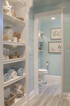 a white toilet sitting in a bathroom next to a shelf filled with lots of towels