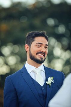 a man in a blue suit smiles at the camera