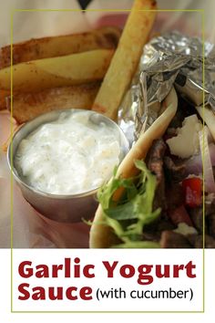 there is a sandwich and french fries on the plate with text overlay that reads garlic yogurt sauce with cucumber