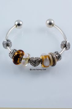 I have made this one of a kind Topaz And Angel Heart Bangle Bracelet from a silver plated brass angel heart bead, lampwork glass beads, silver plated brass locking beads, silver plated brass bangle. Wrist circumference 17cm (6.69inches). Weight: 37g (1.31oz) Adjustable Heart Bracelet With Silver Beads For Gift, Silver Heart-shaped Beaded Bracelets With Charms, Heart Shaped Spacer Beads Jewelry For Gifts, Unique Bangle With Spacer Beads, Silver Spiritual Bracelet With Heart Beads, Silver Metal Beaded Bracelets With Heart Beads, Silver Heart Beads Bracelet For Jewelry Making, Silver Round Bracelets With Heart Beads, Heart Beads Bangle Jewelry For Gift