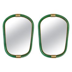 a pair of green mirrors sitting on top of a white wall next to each other