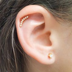 a woman's ear with three small gold stars on the top and bottom of it