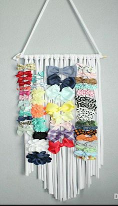 a white wall hanging with many different types of hair bows on it's side