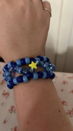 a person wearing blue bracelets with a yellow star on them