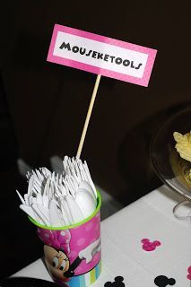 a table topped with lots of cupcakes next to a sign that says mouseketools