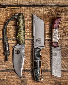 four knives are lined up on a wooden surface