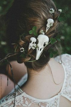 the back of a woman's head with white skulls and flowers in her hair