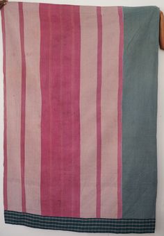 a pink and blue striped blanket hanging on a wall