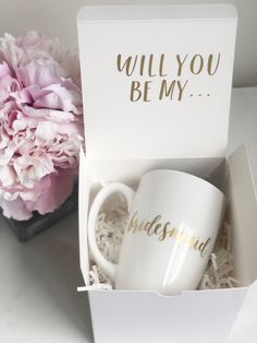 two coffee mugs in a box with the words will you be my bridesmaid written on them