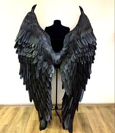 a mannequin with large black wings on it