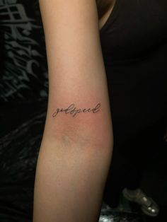 a woman with a tattoo on her arm that reads, godlycupard in cursive writing