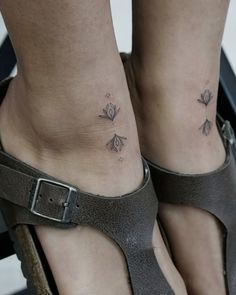 a woman's foot with two small flowers on the side of her ankles and one is