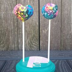 two lollipops sitting on top of each other in front of a wooden fence