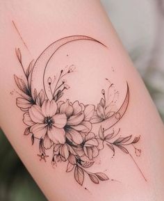 a woman's thigh with flowers on it and the moon behind her tattoo design