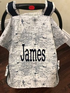 a baby seat cover with the name james printed on it's front and back