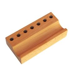 a wooden block with holes in the middle and two holes at the bottom, on a white background