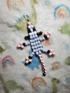 a cross made out of beads sitting on top of a bed