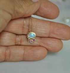 "A tiny, 14K solid gold pendant with beautiful synthetic Opal & Sapphire stones on a 14K solid gold chain. This delicate necklace resembles a flower as if a little blossom is sitting on your chest, the oval Opal is set in the center of the flower and 3 pink Sapphires are set as leaves. I pick the stones one by one, matching the light pink Sapphires color to the beautiful synthetic Opal color. You can wear this gold necklace every day as it goes well with any color of clothing and suitable fo 14k Gold Necklace With Gemstone Flower Pendant, 14k Gold Birthstone Necklace With 17 Jewels, Yellow Gold Birthstone Pendant Necklace As Gift For Her, Oval Pendant Birthstone Necklace In 14k Gold, Dainty Oval Birthstone Necklace In 14k Gold, 14k Gold Oval Pendant Birthstone Necklace Gift, Dainty Oval Hallmarked Necklace, Dainty Yellow Gold Oval Birthstone Necklace, 14k Gold Birthstone Pendant Necklace As Gift For Her