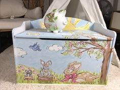 a toy box with an animal scene painted on the front and sides, sitting in a living room