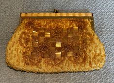 This exquisite vintage handbag is a must-have for anyone who loves vintage accessories. With its stunning gold beaded design and elegant purse style, it is perfect for adding a touch of glamour to any outfit. The intricate beading is a testament to the skill and craftsmanship of the artisans who created it, making it a unique and special piece. Crafted from high-quality materials, this handbag is not only beautiful but also durable and functional. It is perfect for carrying all your essentials, whether you are heading out for a night on the town or just running errands. So why wait? Add this stunning piece to your collection today and experience the timeless beauty of vintage fashion. Retro Gold Bag As A Gift, Gold Clutch With Gold Embroidery For Formal Occasions, Elegant Beaded Evening Bag For Vintage Events, Elegant Gold Clutch Coin Purse, Elegant Evening Clutch With Gold Beads, Elegant Yellow Evening Bag For Formal Occasions, Gold Chic Evening Coin Purse, Gold Beaded Evening Bag For Wedding, Gold Embroidered Evening Bag Gift