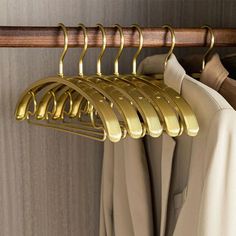 gold colored clothes hangers are hanging on a coat rack