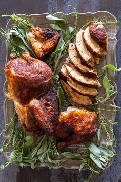 roasting chicken with herbs and sliced potatoes on a platter, ready to be served