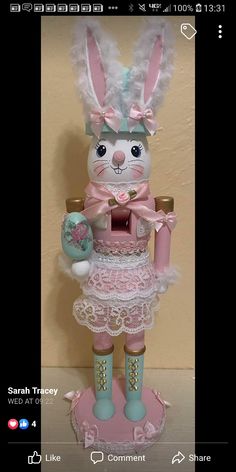 a rabbit figurine with pink and white laces on it's legs