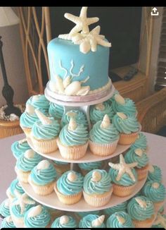 a three tiered cake with blue frosting and starfish decorations