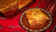 a casserole dish with meat and cheese in it on a red tablecloth