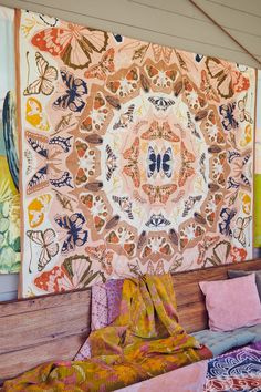 a large tapestry hanging on the wall above a bed