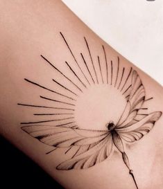 a black and white photo of a sun tattoo on the side of a woman's thigh