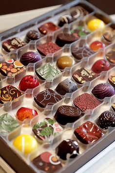 a box filled with lots of different types of chocolates on top of a table