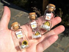 three small glass bottles with tiny flowers in them