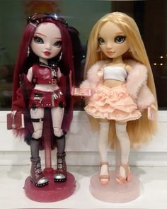 two dolls are standing next to each other